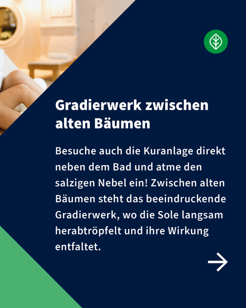 Texttafel mit Einladung, das Gradierwerk zwischen alten Bäumen zu besuchen und den salzigen Nebel einzuatmen – Erholung pur in der Kuranlage.