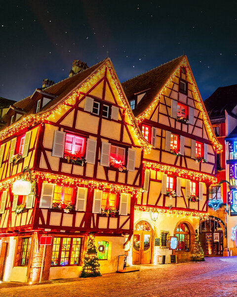Beleuchtetes Fachwerkhaus in Hann. Münden bei Nacht, festlich dekoriert mit Lichterketten, Weihnachtskränzen und geschmückten Fenstern.