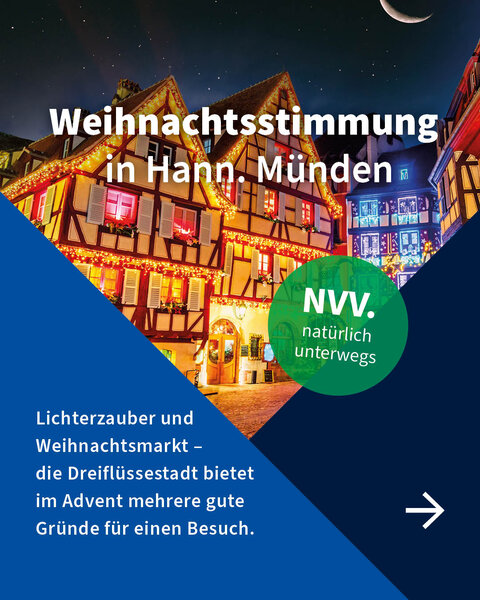 Fachwerkhäuser mit festlicher Weihnachtsbeleuchtung in Hann. Münden bei Nacht, darunter Text über die besondere Adventsstimmung der Stadt.